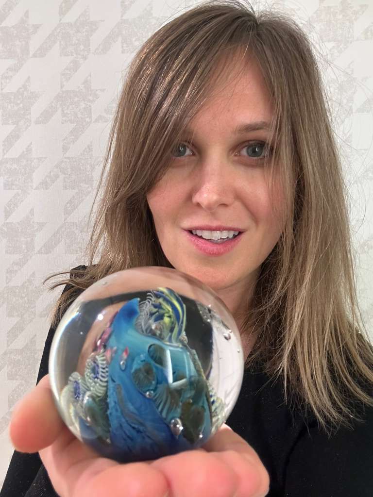 Dr. Ulyana Peña holding a glass globe